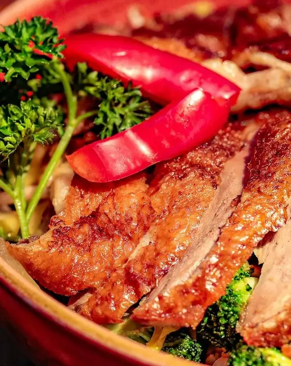 Knusprig gebratene Entenscheiben mit Kräutern und Paprika